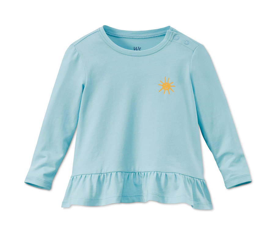 Ein hellblaues Langarmshirt aus Bio-Baumwolle mit gelber Sonne. Das Shirt hat einen Rüschensaum.