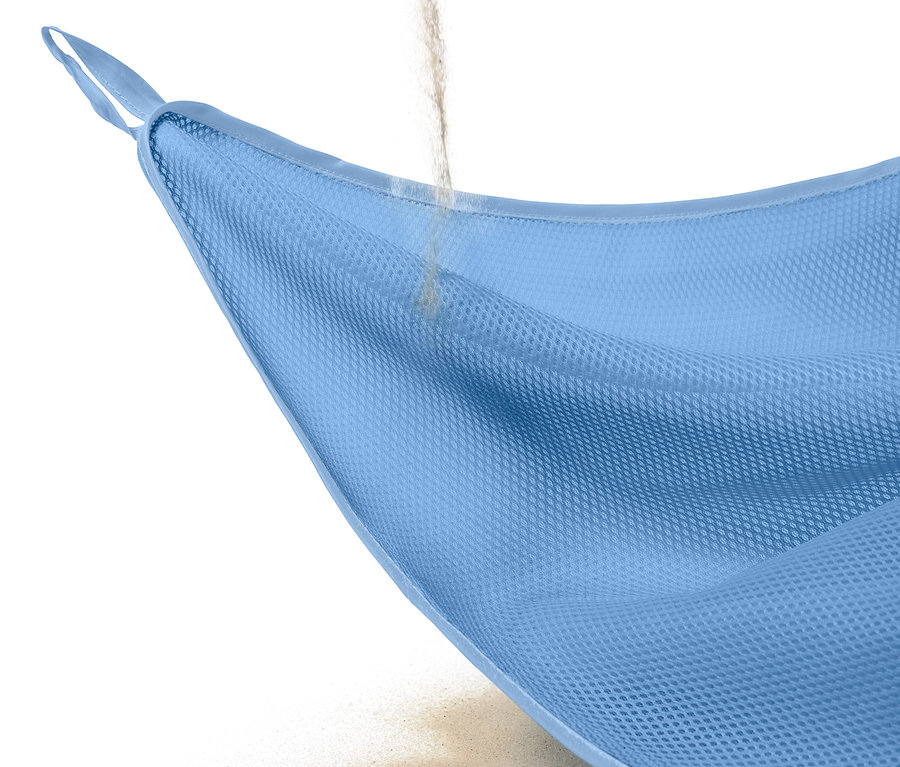 Sand rieselt durch eine hellblaue sandfreie Stranddecke.