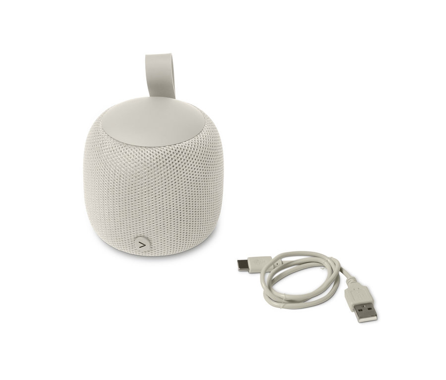 Ein grauer, kleiner Fabric-Bluetooth®-Lautsprecher und ein USB-Kabel auf einem weißen Hintergrund.