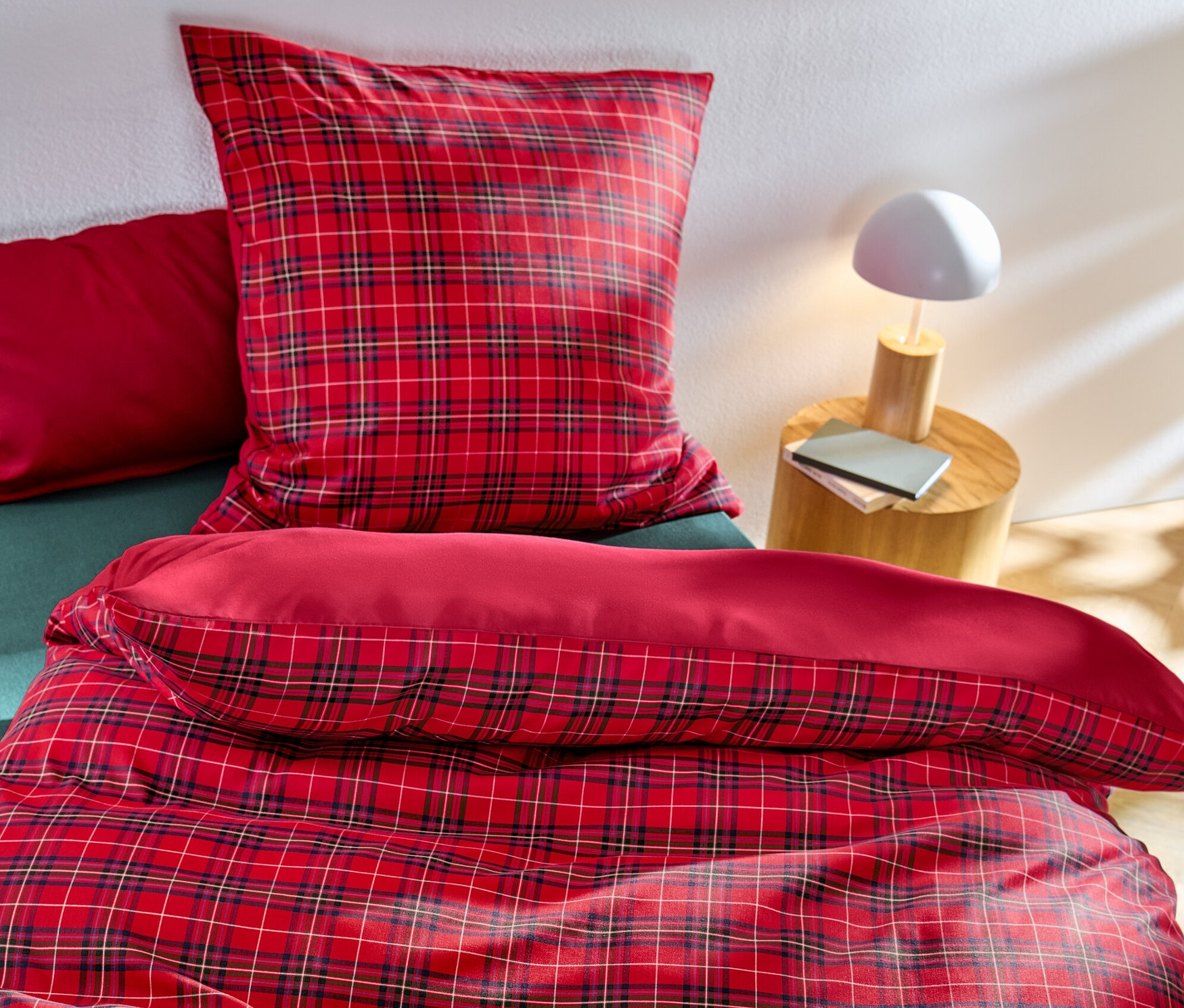 Rot karierte Microfaser-Bettwäsche in Normalgröße und Übergröße auf einem Bett.
