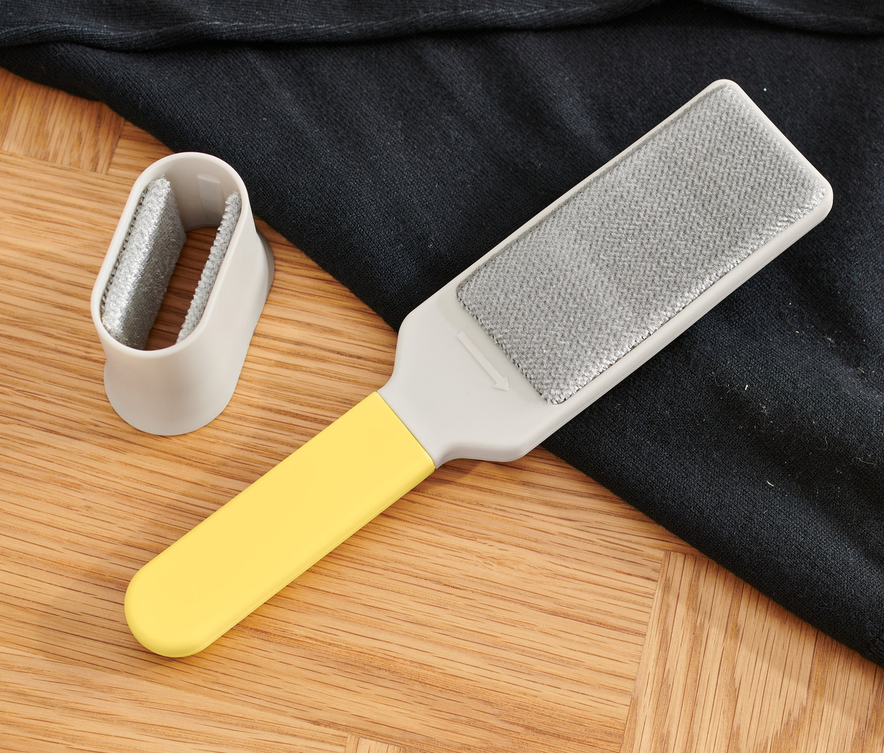 Doppelseitige Kleiderbürste liegt auf Pullover.