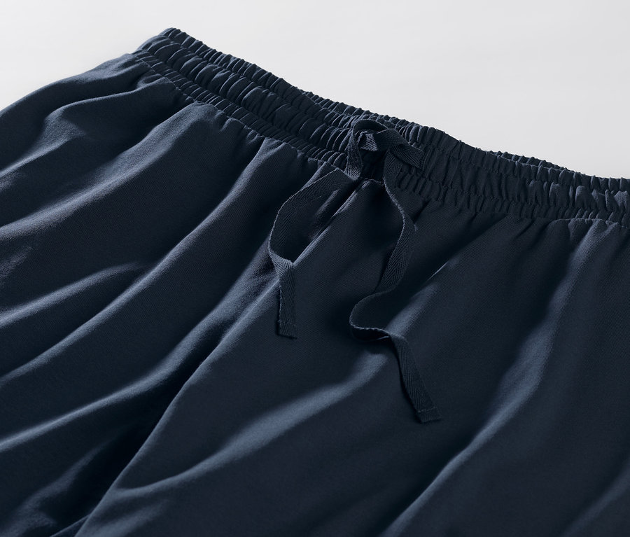 Detail einer blauen, gestreiften Pyjamahose mit elastischem Bund und Kordelzug.