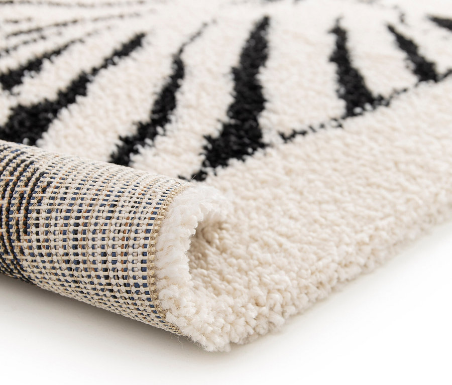 Detailansicht eines zusammengerollten Kinderteppichs NOMAD Zebra, ca. 120 x 170 cm auf weißem Hintergrund.