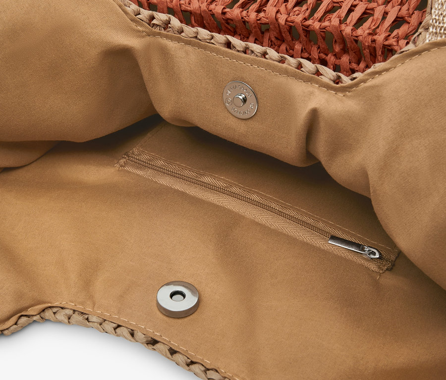 Detailansicht eines Bast-Shoppers mit braunem Stofffutter und einer Innentasche mit Reißverschluss.