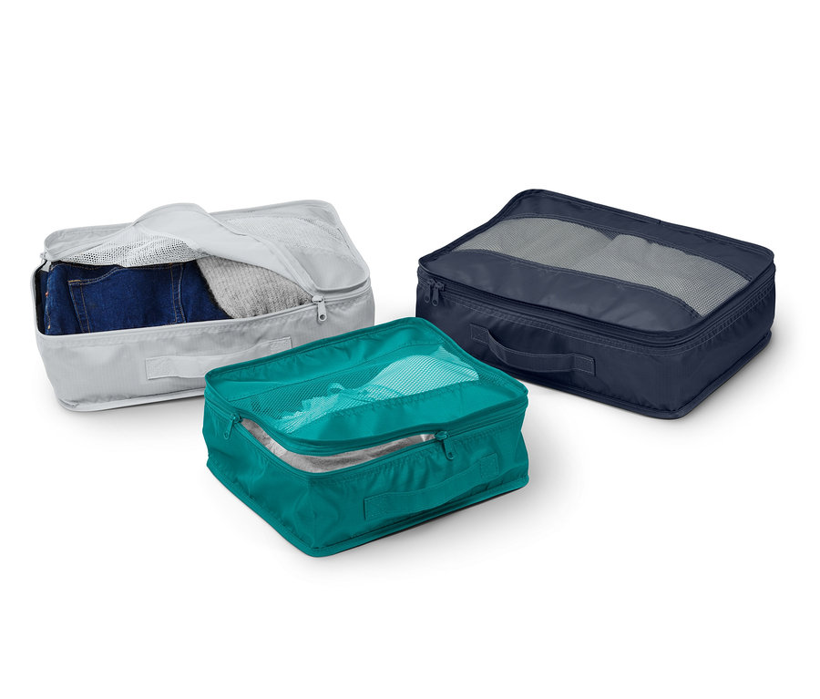 Drei Reiseordnungstaschen in Grau, Türkis und Dunkelblau.