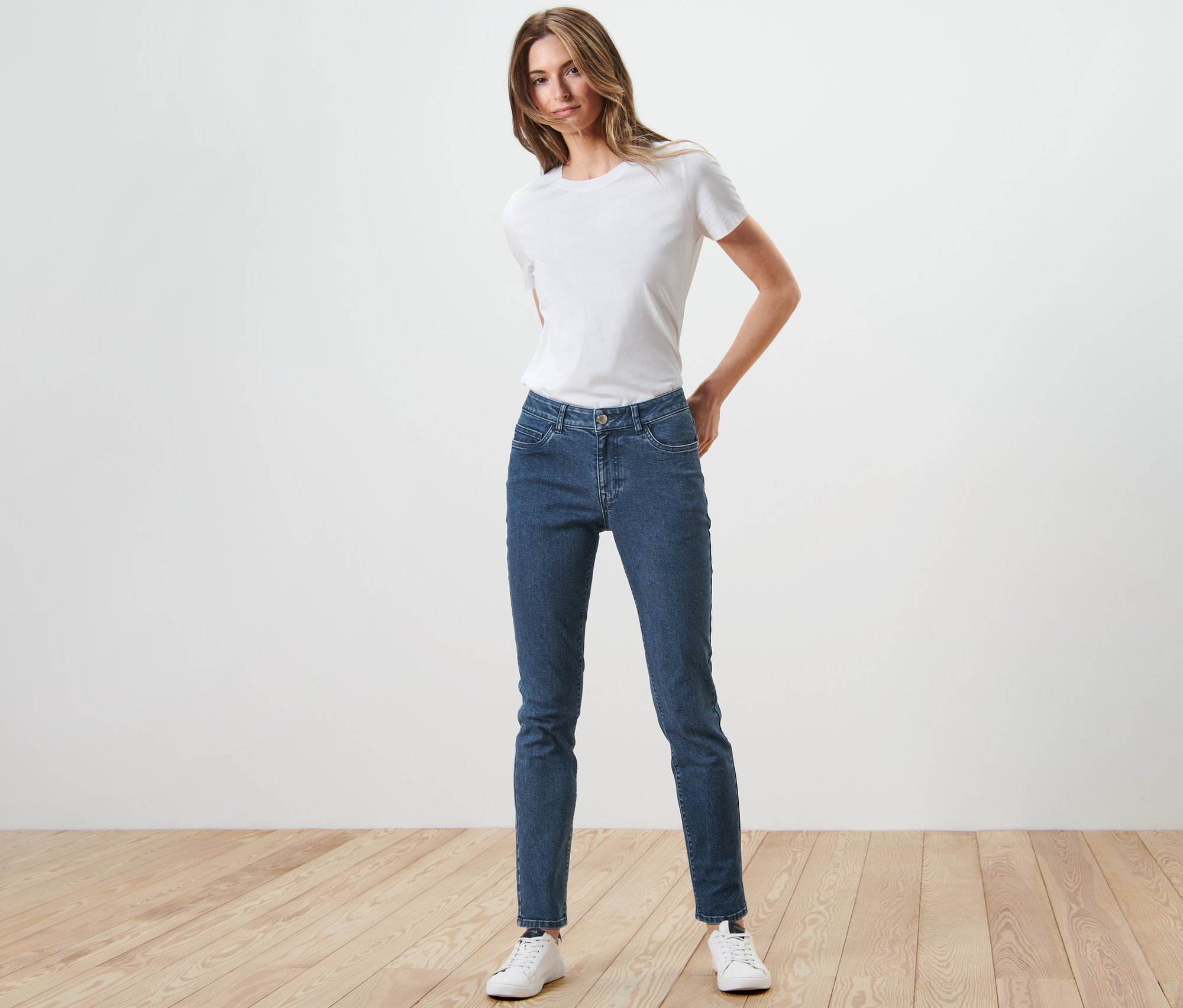 Frau posiert in Slim Jeans – Fit »Emma« und weißem T-Shirt.