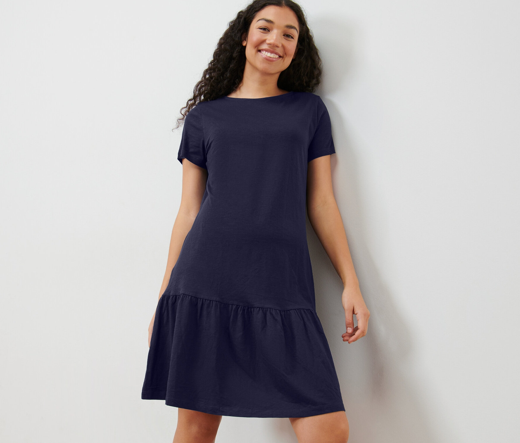 Frau trägt ein dunkelblaues Jerseykleid mit Volant.