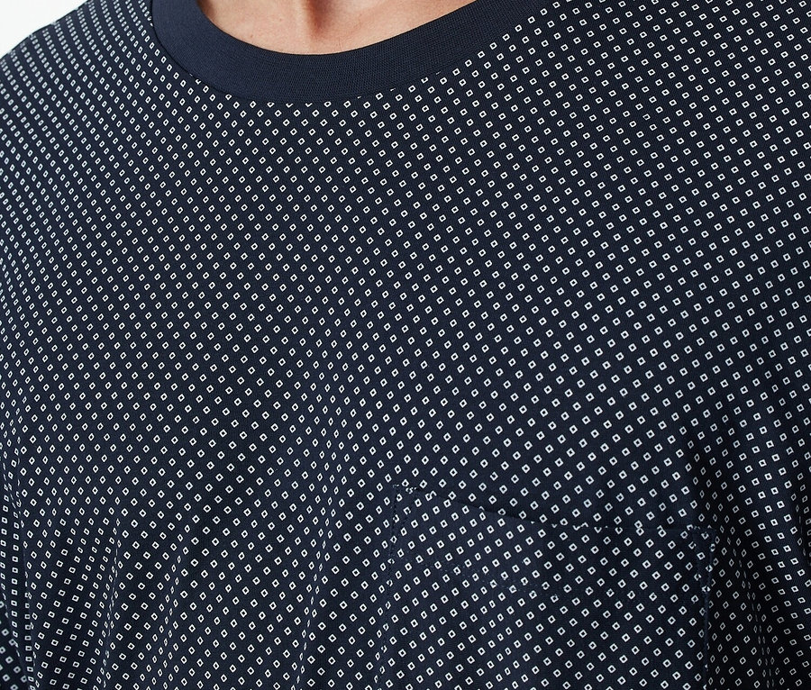 Mann trägt ein dunkelblaues T-Shirt mit weißem Muster.