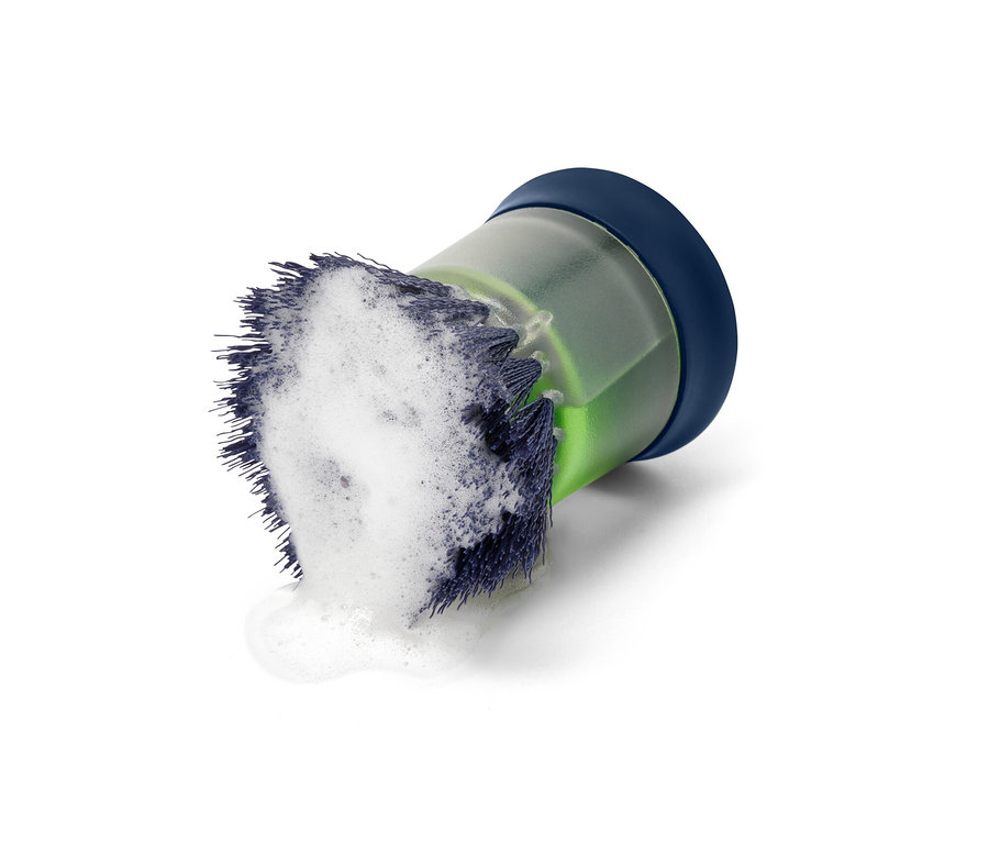 Spülbürste mit Spender, blauem Deckel und Schaum auf den Borsten.