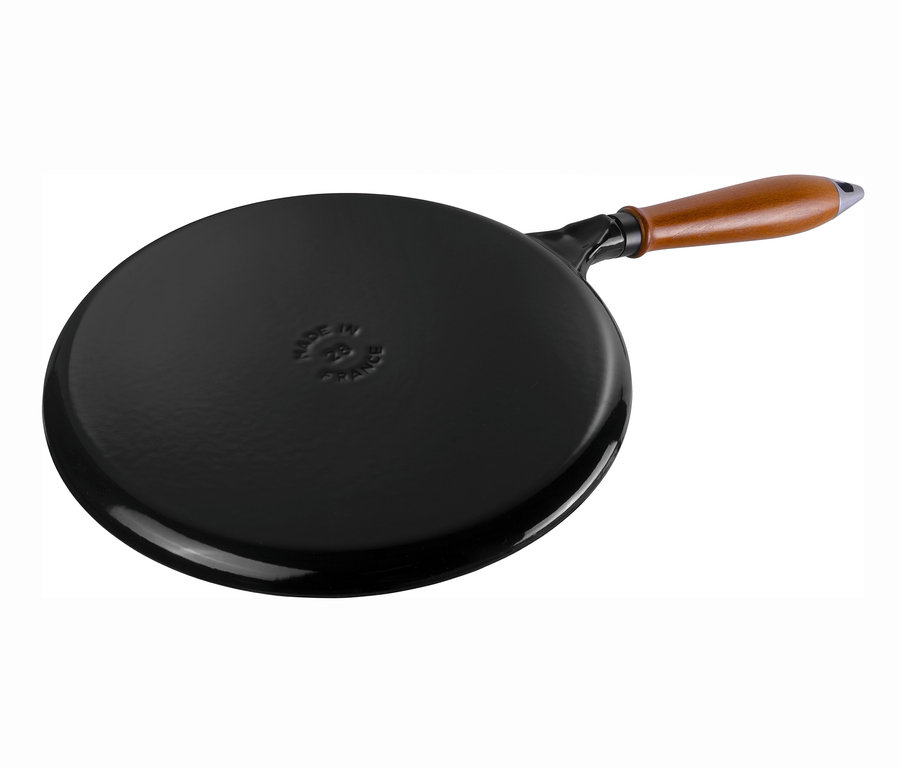 Schwarze STAUB Pfannkuchenpfanne mit Holzgriff.
