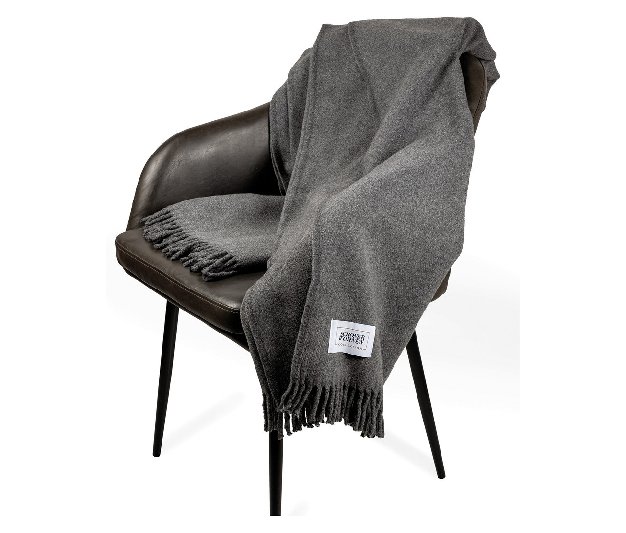 Eine graue Decke mit Fransen liegt auf einem braunen Stuhl.
