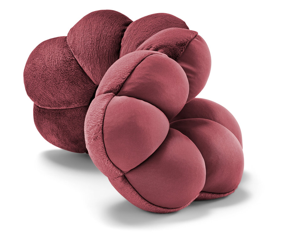 Detailansicht eines weinroten Kissens in Blütenform.