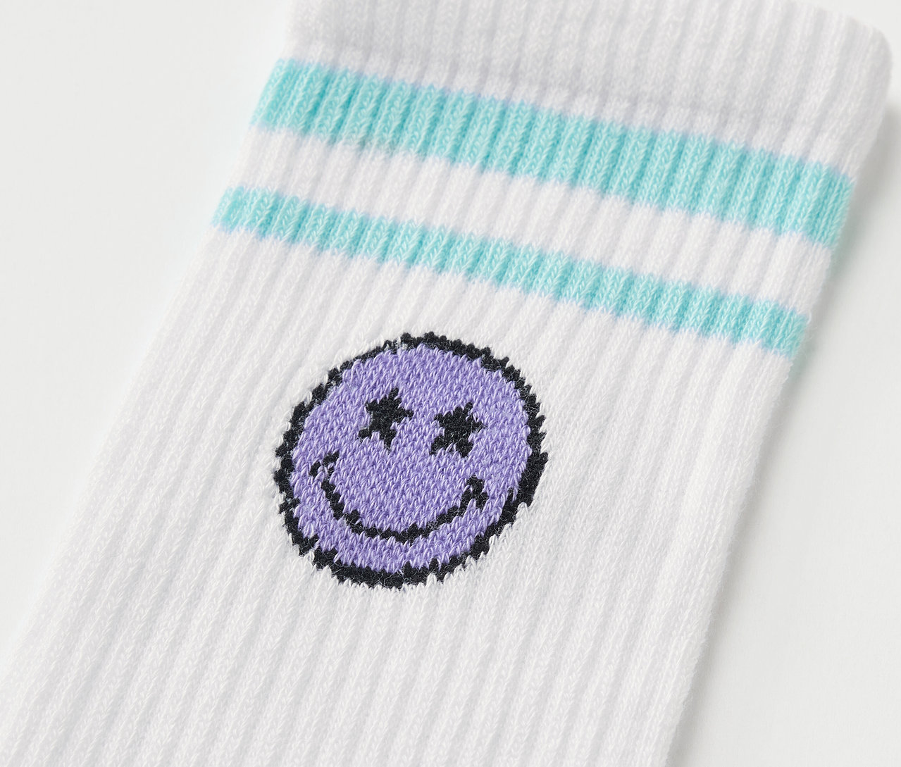 Detailaufnahme einer weißen Socke mit blauen Streifen und einem lila Smiley. 5 Paar Kinder-Tennissocken SMILEYWORLD®.