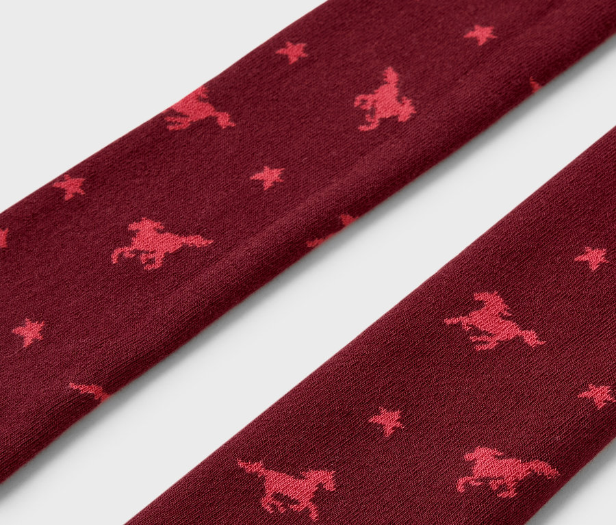 Detailaufnahme von bordeauxfarbenen Thermoleggings mit Pferde- und Sternmuster.