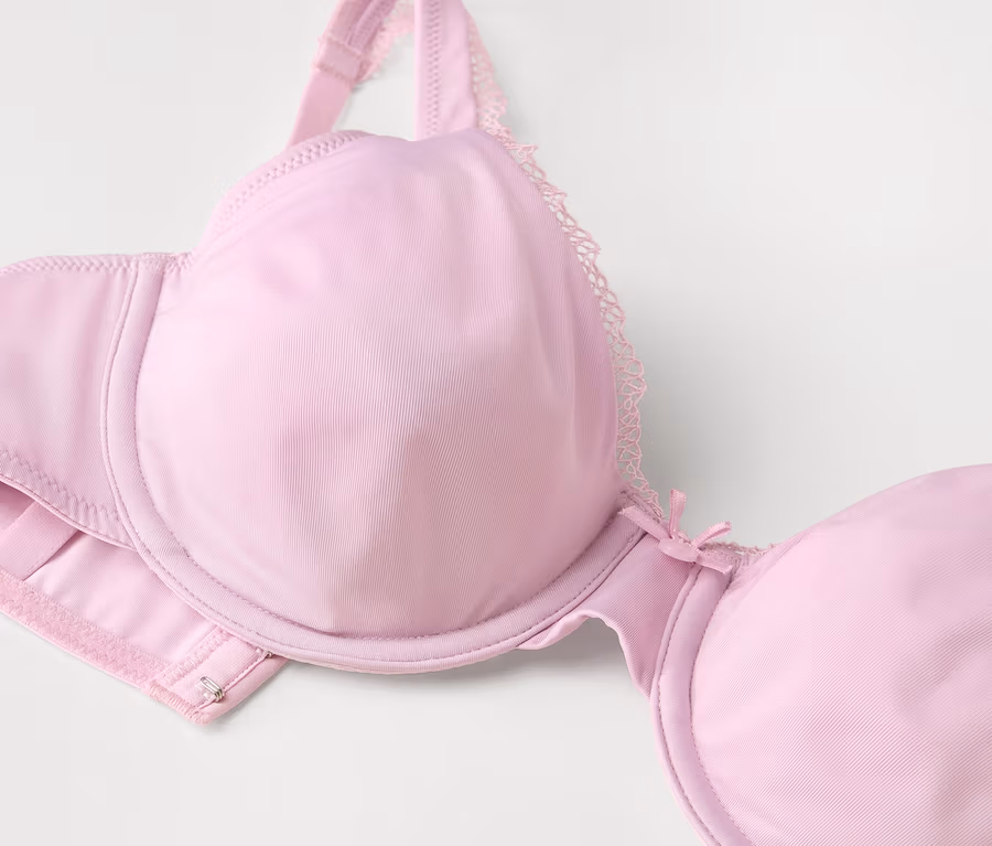 Detailaufnahme eines hellrosa Bügel-BHs mit Spitze.