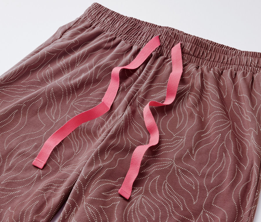 Detailaufnahme einer Pyjamahose mit Blattmuster und pinkfarbenem Kordelzug.