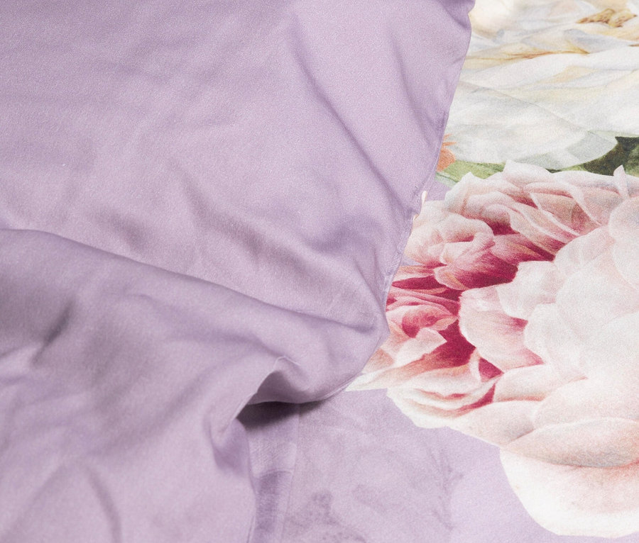 Nahaufnahme von lila Bettwäsche mit Blumenmuster.