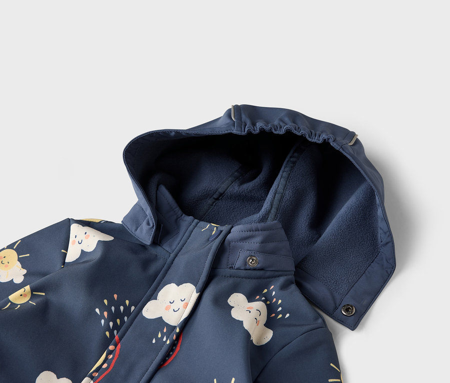 Detailansicht einer marineblauen Jacke mit Kapuze, verziert mit Wolken- und Sonnenmotiven.