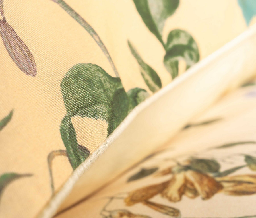 Nahaufnahme eines hellgelben Stoffes mit Blumenmuster.