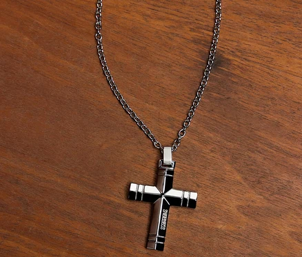 Amor Unisex-Halsschmuck mit Kreuz-Anhänger auf einem Holztisch.