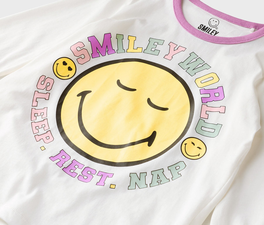 Weißes Langarmshirt mit einem großen gelben Smiley-Gesicht und dem Schriftzug "Smiley World, Sleep, Rest, Nap".