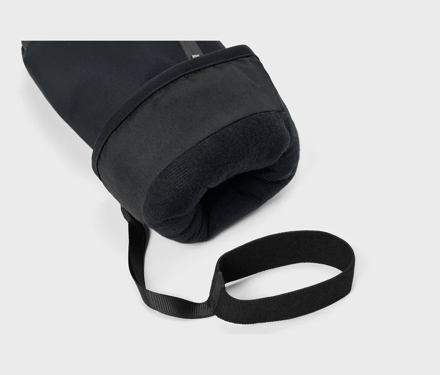 Nahaufnahme des Bündchens eines schwarzen Handschuhs oder Ärmels mit weichem, flauschigem schwarzem Futter und einem angebrachten schwarzen Riemen.