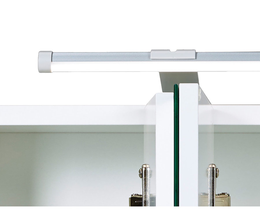 Eine silberne lineare LED-Leuchte beleuchtet einen weißen Schrank mit zwei Glastüren, die Metallscharniere zeigen.