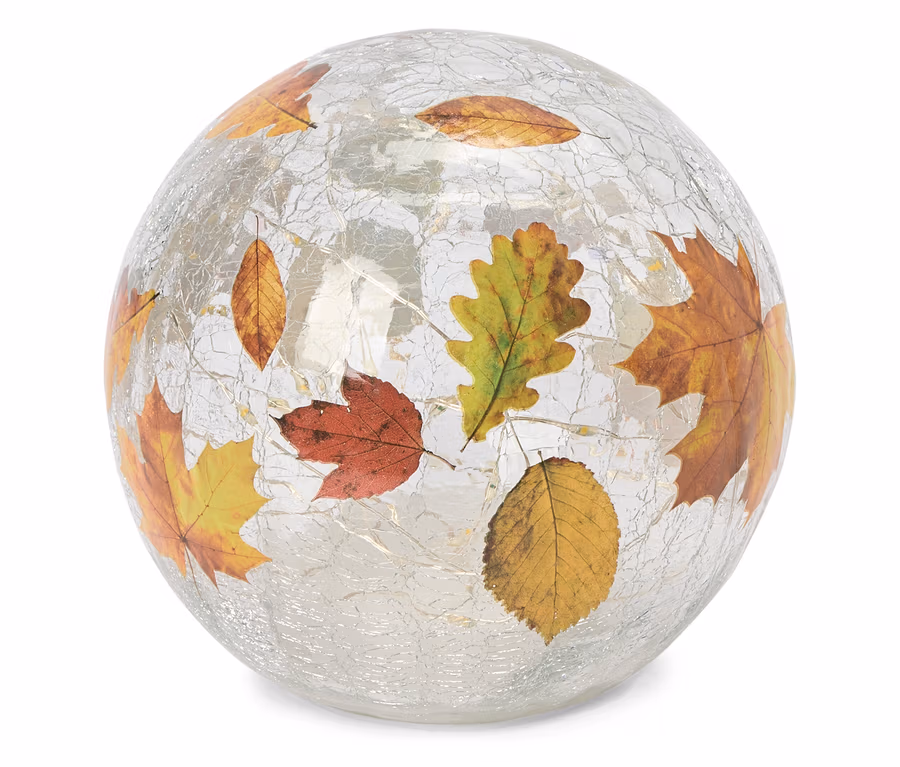 Eine kugelförmige, rissige Glas-Dekorationsleuchte mit verschiedenen Herbstblättern in Rot, Orange, Gelb und Grün, die auf ihrer Oberfläche eingebettet sind und von innen leuchten.