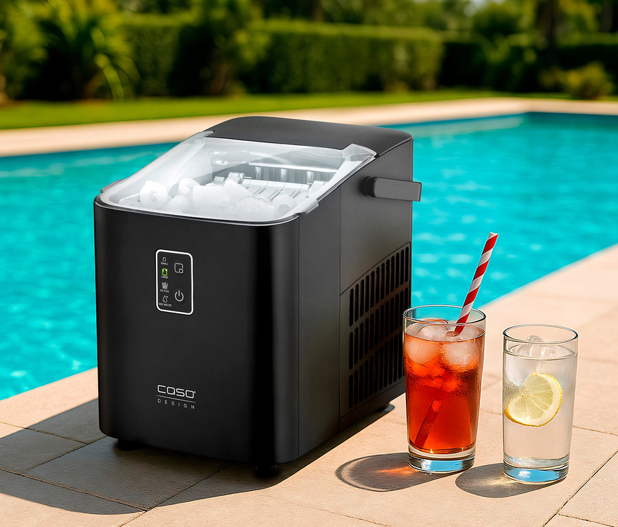 Schwarzer CASO IceChef Compact Eiswürfelbereiter, gefüllt mit Eiswürfeln, steht neben einem Pool. Daneben sind zwei Gläser mit Eisgetränken, eines mit rotem Getränk und Strohhalm, das andere mit klarem Getränk und Zitronenscheibe.