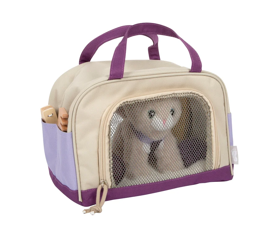 small foot Plüschkatze mit Tasche und Pflege-Set: Eine beigefarbene und lila Tragetasche mit einer Plüschkatze und Holzpflegezubehör in der Seitentasche.
