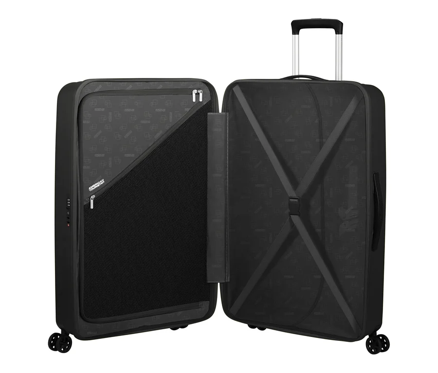 Offener, großer, schwarzer American Tourister Rejoy Spinner Koffer. Die linke Seite zeigt eine große Netztasche und eine kleinere Reißverschlusstasche, die rechte Seite hat elastische Kreuzgurte.