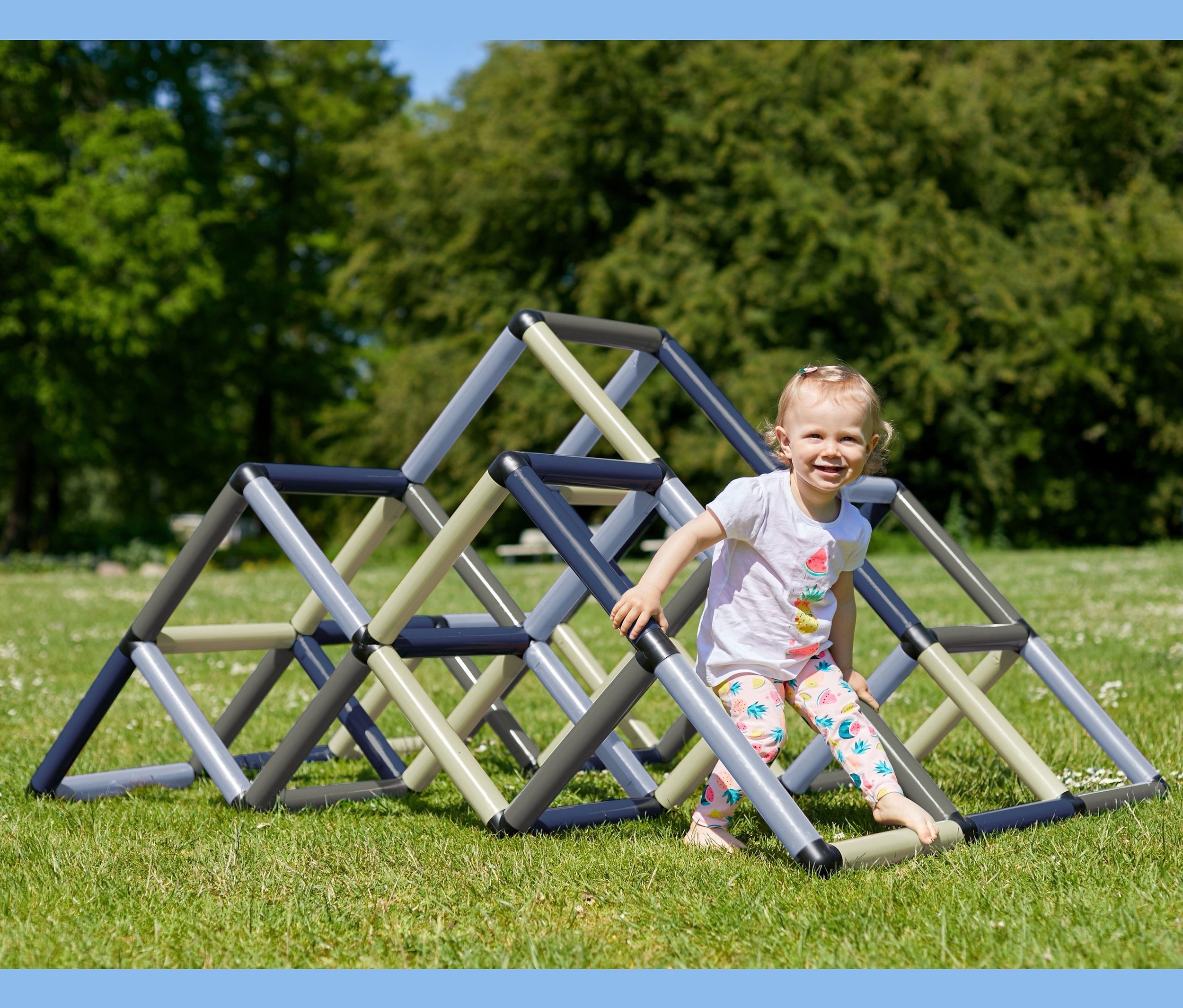 Mädchen klettert auf petrolfarbener Quadro-Home-KLETTERPYRAMIDE auf Rasen.