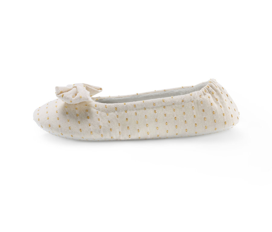Ein beiger Ballerina-Hausschuh mit Schleife und goldenen Punkten.