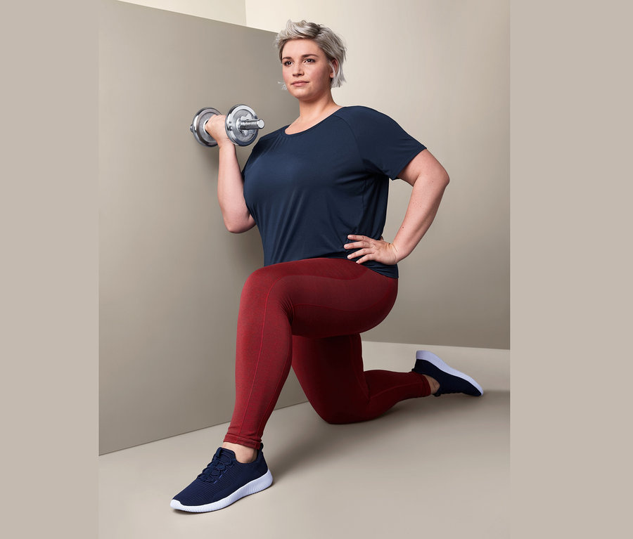 Frau macht Ausfallschritte mit einer silbernen Hantel, sie trägt ein Sportshirt und eine Seamless-Funktions-Sporttights.