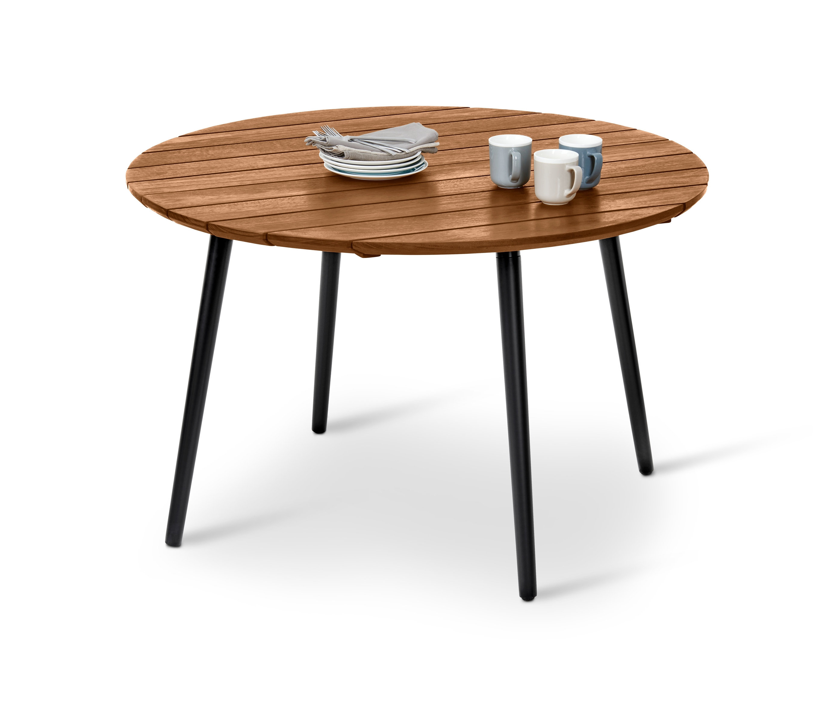 Ein runder Gartentisch mit einer Serviette, Tellern und drei Tassen.