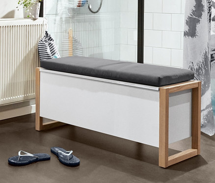 Badezimmer-Interieur mit Bad-Hochschrank, Waschbeckenunterschrank, Standregal mit 3 Stauraum-Kästen, Beistellwagen, Vogelgesangs-Box, Stauraumsitzbank, Duschvorhang, Badematte (türkis) und Bade-Zehentrenner.
