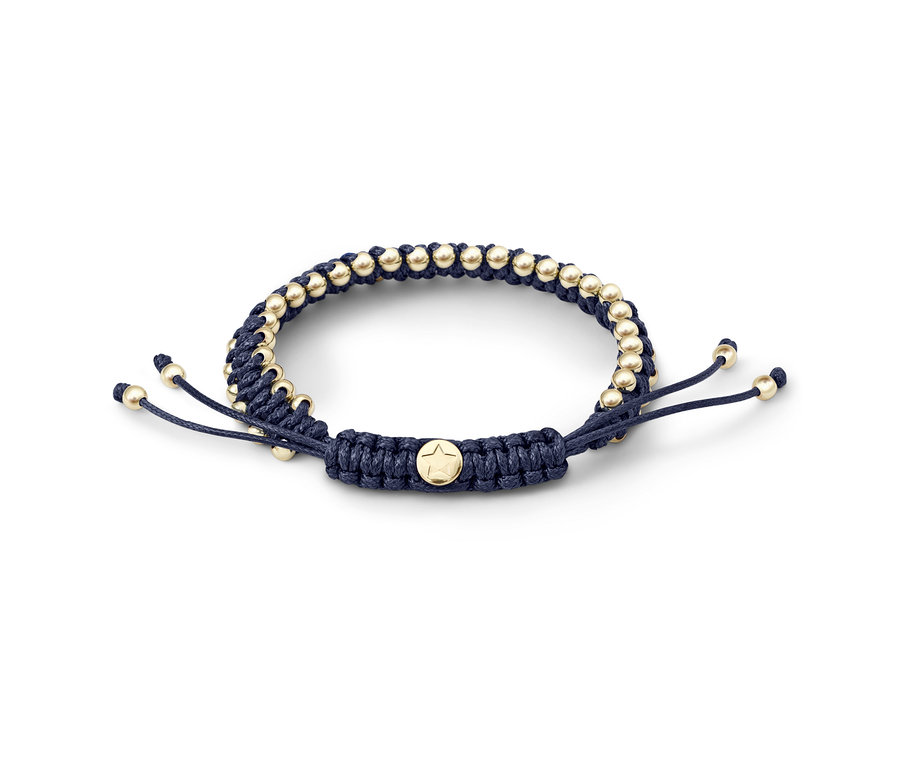 Detailansicht eines geknüpften, blauen Magnetarmbands mit goldenen Perlen.