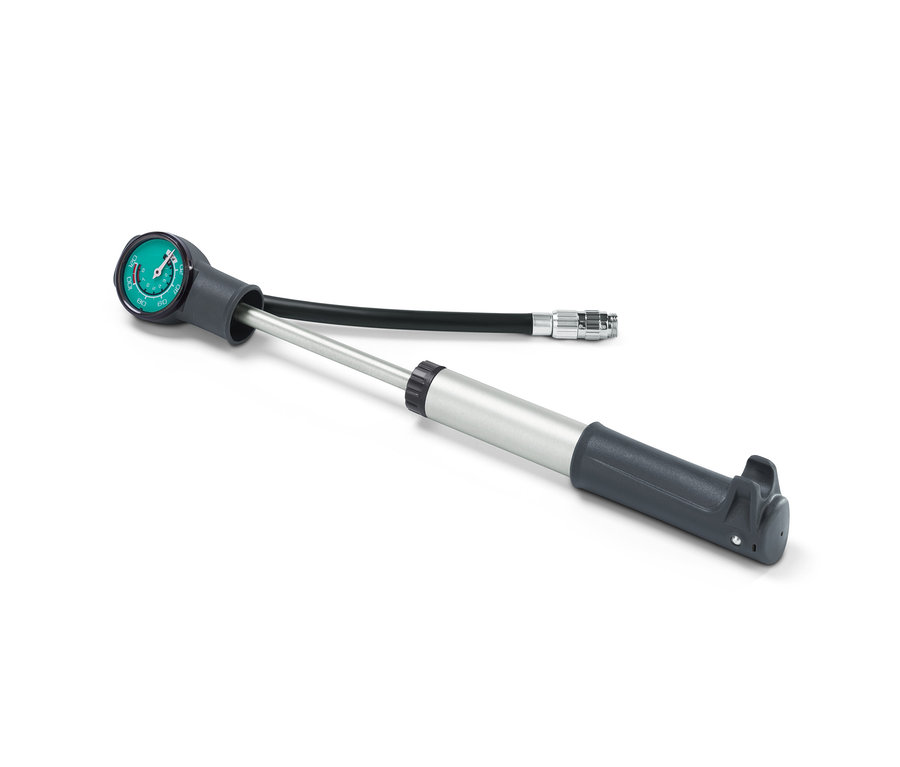 Eine graue 2-Wege-Minipumpe mit Manometer und Schlauch liegt auf einem weißen Hintergrund.