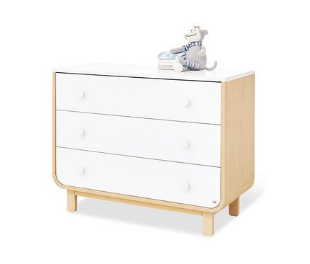 Weiße Pinolino Wickelkommode »Round«, breit mit drei Schubladen und Holzdetails. Auf der Kommode liegt ein Plüschaffe.