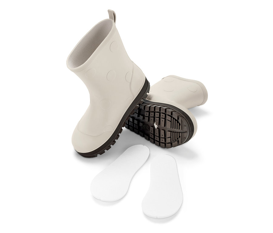 Zwei Gummistiefel und Schuheinlagen auf weißem Hintergrund.