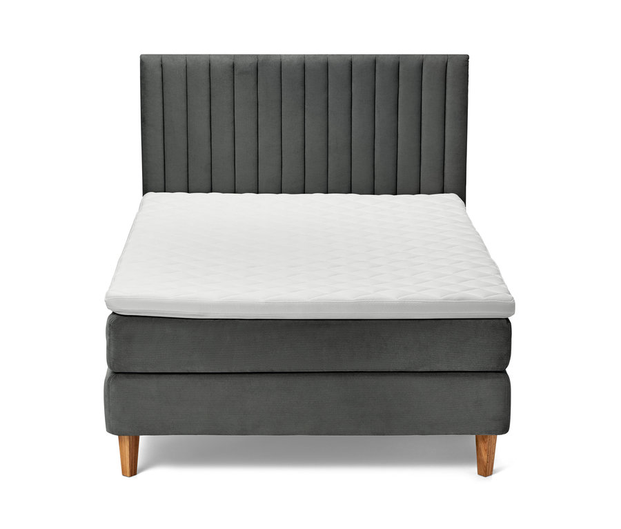 Anthrazitfarbenes Boxspringbett mit weißer Matratze und Holzfüßen.