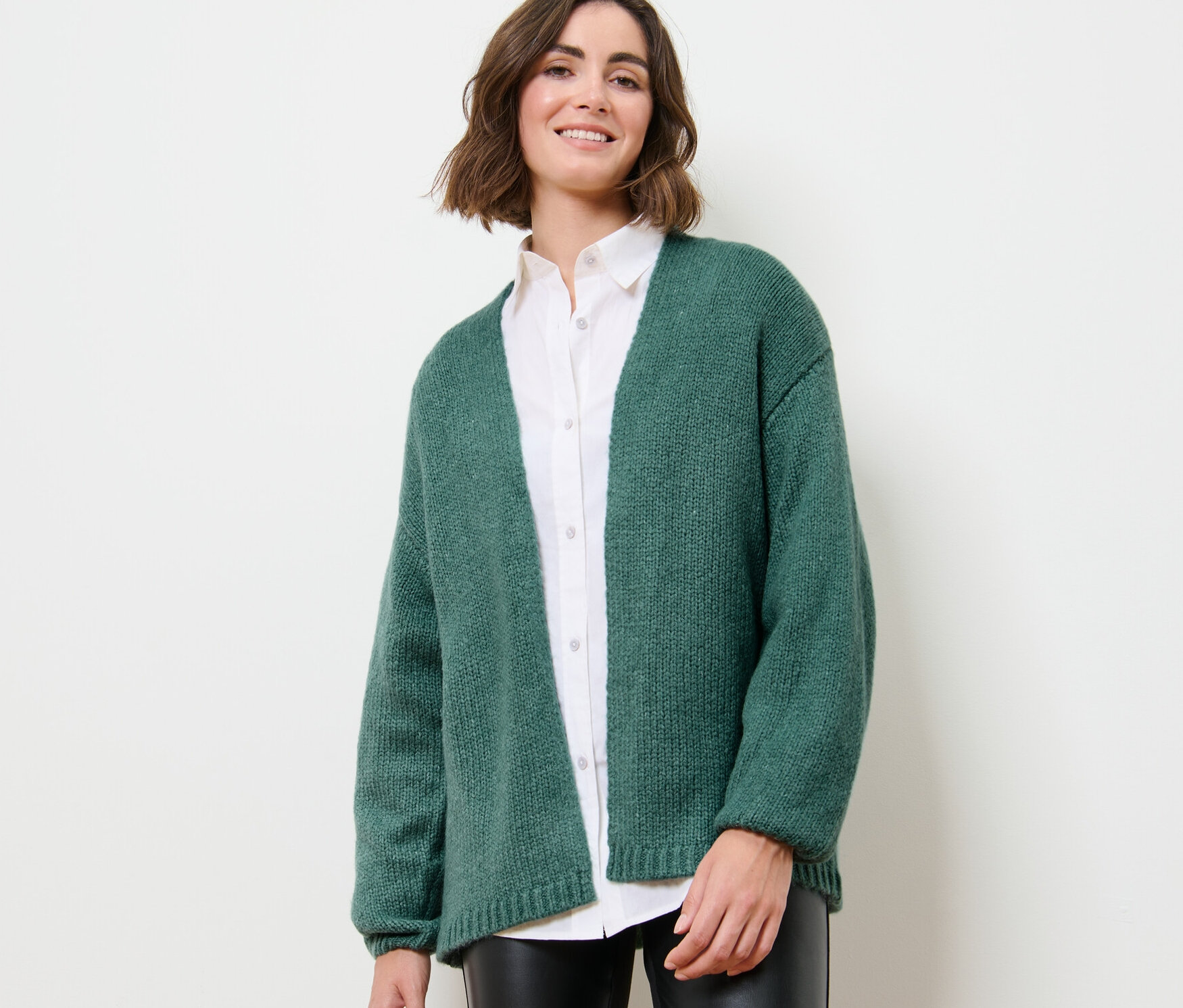 Frau trägt offenen Grobstrick-Cardigan.