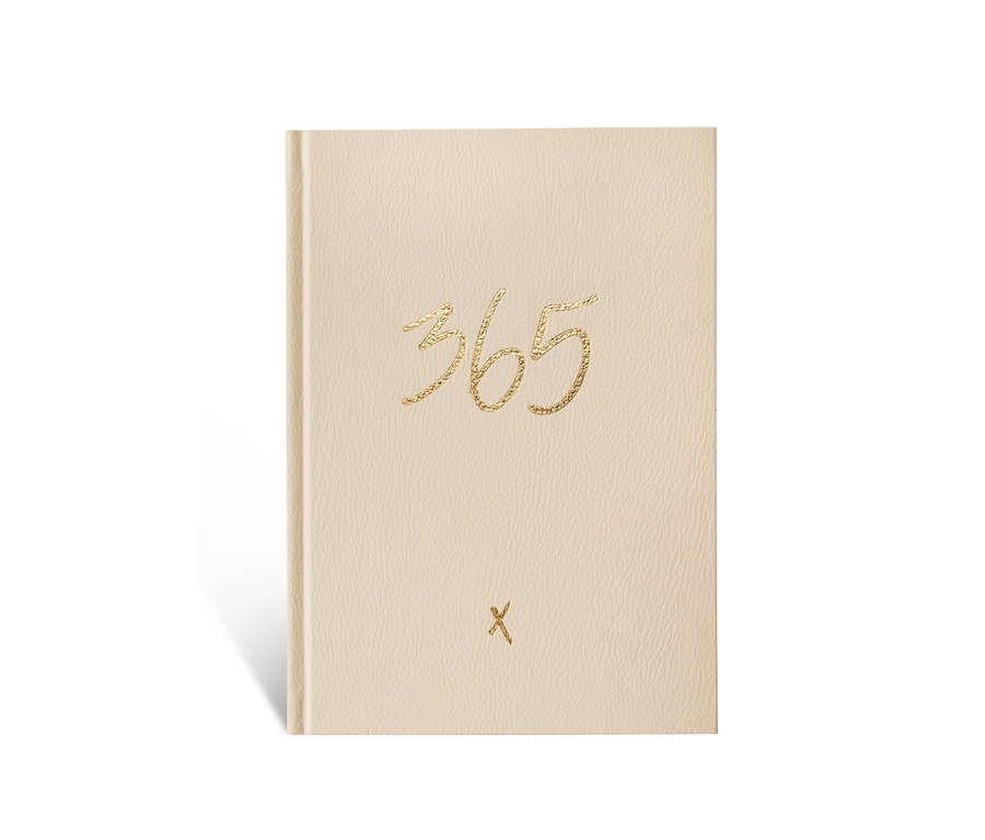 Ein elfenbeinfarbenes Notizbuch »365« liegt auf einem weißen Untergrund.
