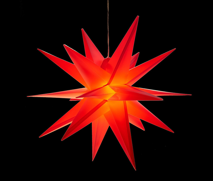 Ein roter AMARE LED-3D-Außenstern hängt vor einem schwarzen Hintergrund.