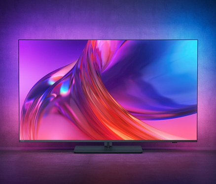 Ein schwarzer Philips 4K UHD Ambilight TV mit Google TV zeigt eine abstrakte Grafik.
