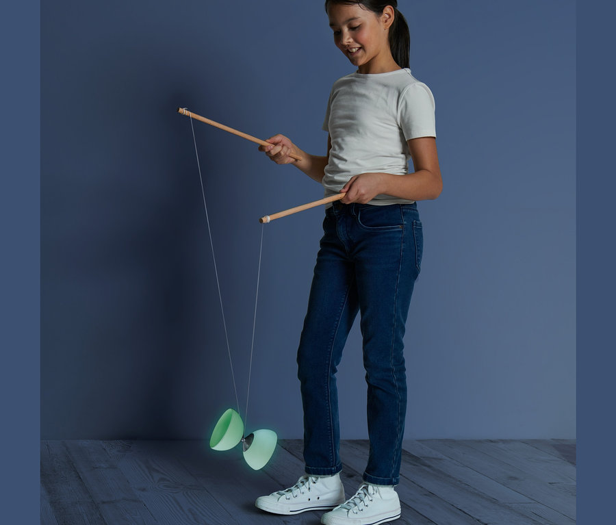 Mädchen spielt mit einem Diabolo »Glow in the dark«.