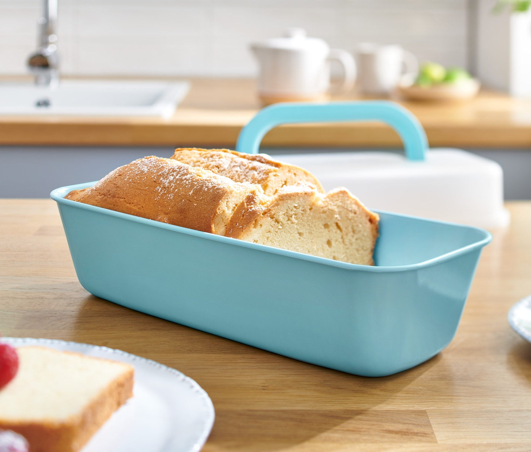 Geschnittenes Brot in Kastenform mit Deckel auf einem Holztisch.