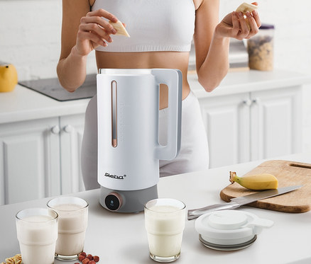 Frau gibt Banane in Steba Vegan-Drink-Maker »VDM 2 HOT & COLD«.