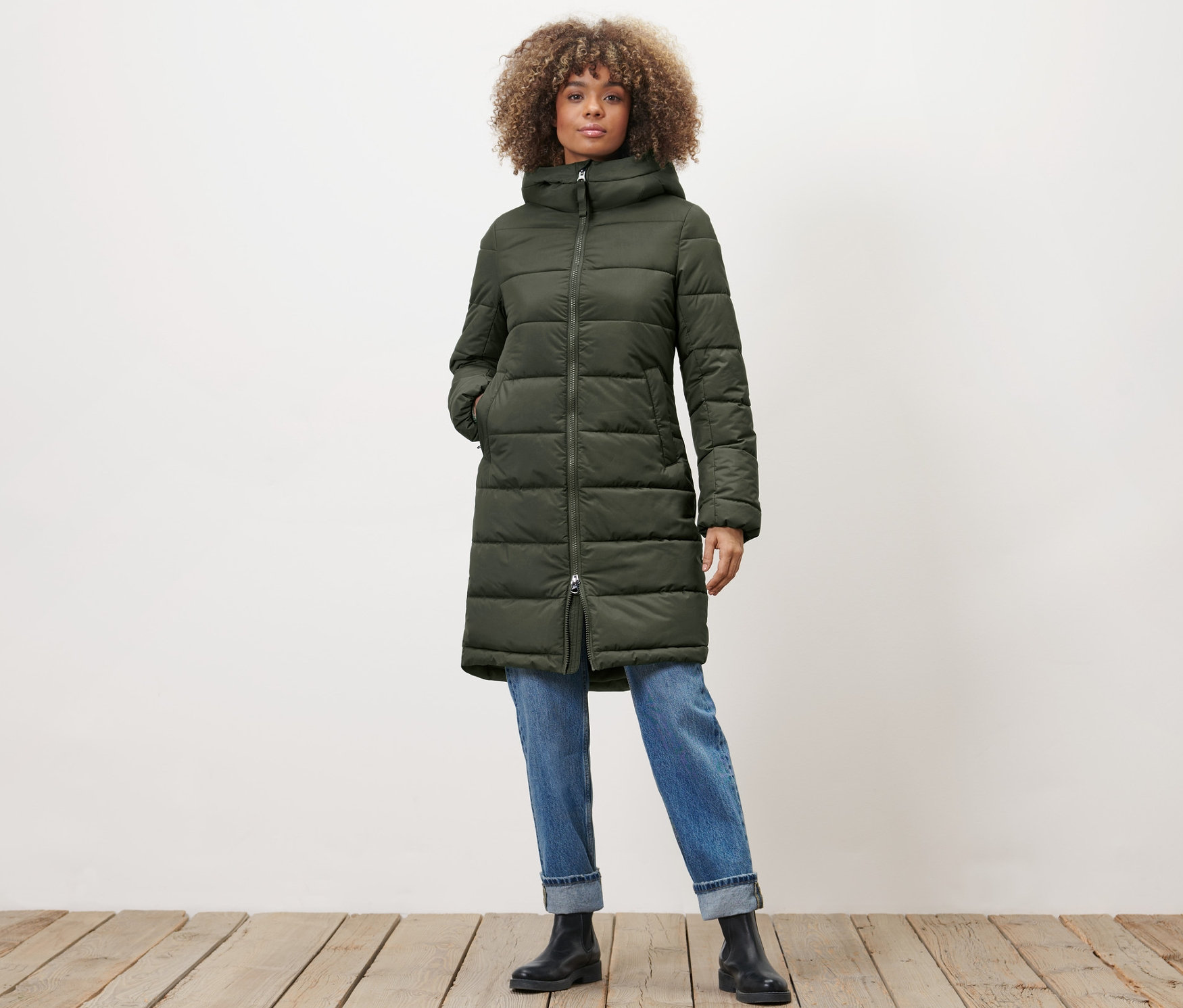 Frau posiert in khaki Steppmantel.