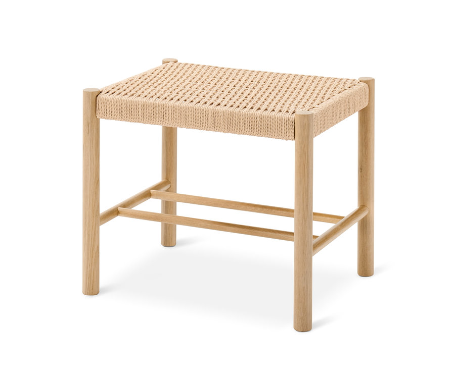 Ein heller Holzhocker mit geflochtener Sitzfläche.